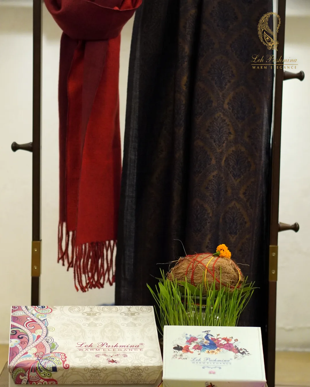 A His & Her pair: red muffler and navy paisley stole, with Leh Pashmina gift boxes and Diwali decor